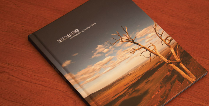 The cover of the hard-back photography book Red Marauder, featuring original photography. The cover photo was taken overlooking the near-empty Lake George, just outside of Canberra.